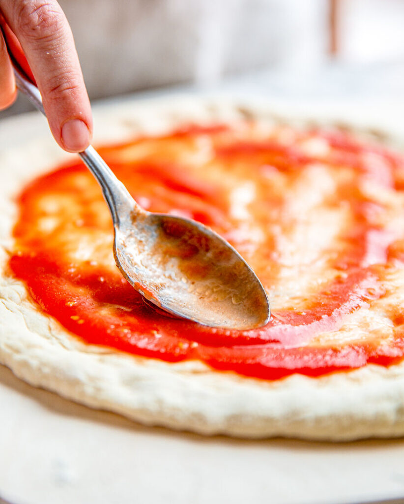 San Marzano sosu pizza hamurunun üzerine dökün